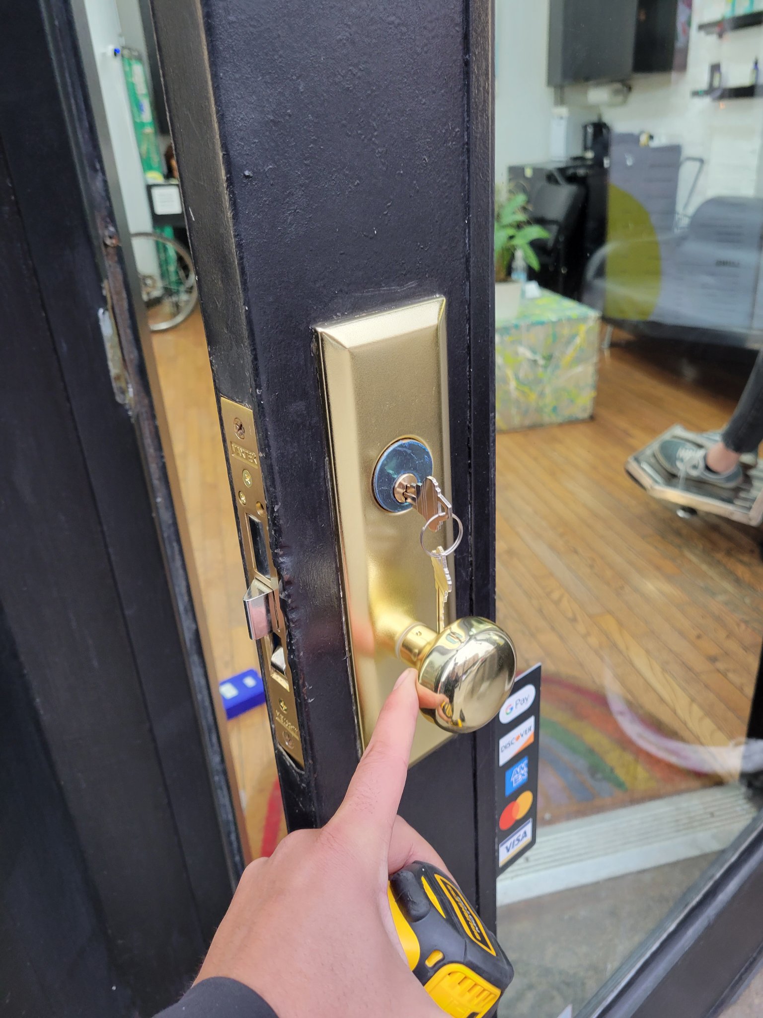 Storefront glass door lock installation in progress